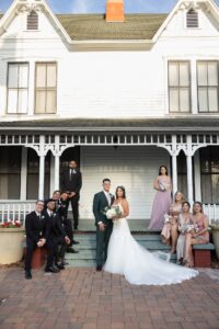 A bridal party standing in front of the Wither Maguire House at Ocoee Lakeshore Center.