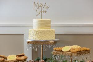 A desert bar at a wedding reception at Ocoee Lakeshore Center featuring a two-tier cake and cookies.