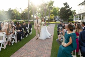 A bride walking down the aisle with her father at the wedding garden at Ocoee Lakeshore Center.