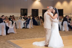 A bride shares a dance with her father on the dance floor inside a wedding reception at Ocoee Lakeshore Centers ballroom.