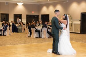 A bride and groom share a first dance on the dance floor inside a wedding reception at Ocoee Lakeshore Centers ballroom.