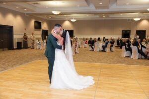 A bride and groom share a first dance on the dance floor inside a wedding reception at Ocoee Lakeshore Centers ballroom.