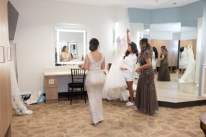A bride in a white robe holding her wedding dress inside of a bridal suite at Ocoee Lakeshore Center.