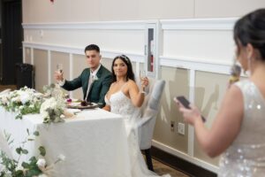 A bride and groom toast to the maid of honors speech inside the ballroom at Ocoee Lakeshore Center.