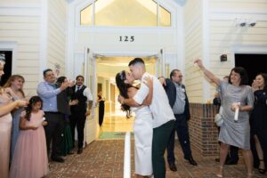 A bride and groom kiss whiling they exit their wedding reception with confetti hearts thrown at Ocoee Lakeshore Center.