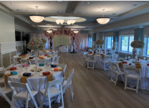 A wedding reception with white linen round tables and colorful decor inside Ocoee Lakeshore Centers Lakeview Room.