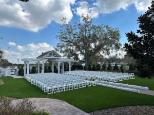 Ocoee Lakeshore Centers Wedding Garden outside of the Withers Maguire House lined with white chairs and set up for a wedding ceremony.